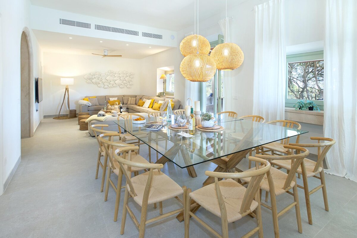 A dining room with a glass table and chairs