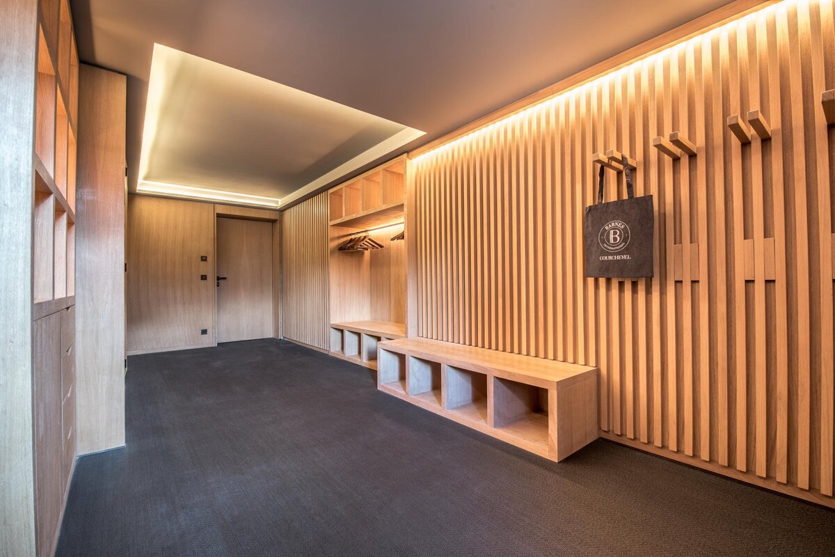 A black bag with the letter b on it hangs on a wooden wall