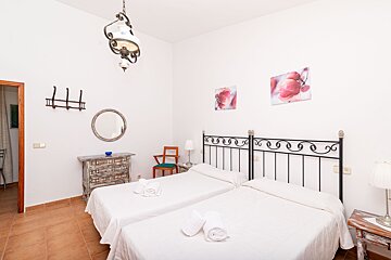 A bedroom with two beds a dresser and a mirror