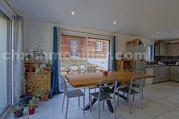 A dining room with a table and chairs and a sliding glass door that says chximmobilier.com