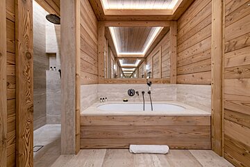 A bathroom with wooden walls and a bathtub