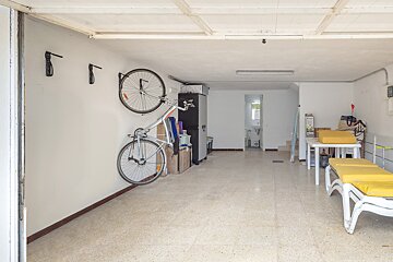 A bicycle is hanging on a wall in a garage