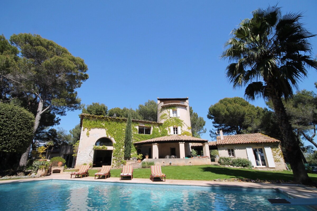 A large house with a swimming pool in front of it