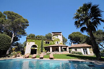 A large house with a swimming pool in front of it