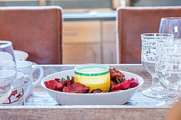 A bowl of dried flowers and a candle on a table