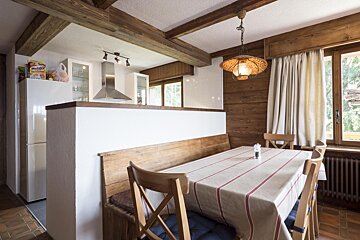 A kitchen with a table that has a striped table cloth on it