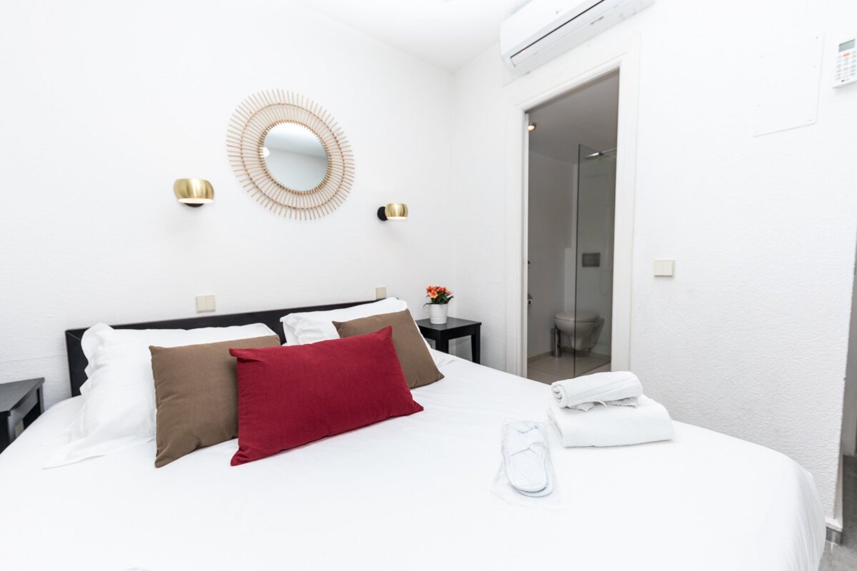 A bedroom with a red pillow on the bed