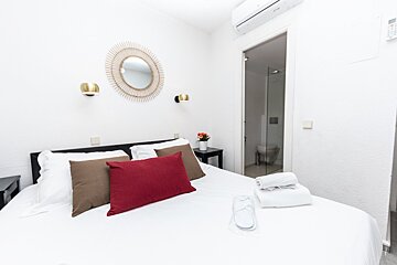 A bedroom with a red pillow on the bed