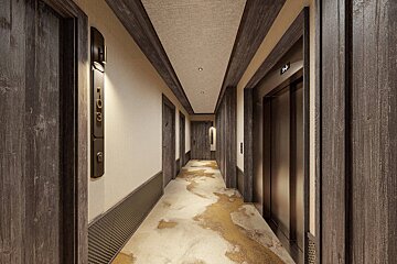 Modern hotel corridor featuring dark wood trim, patterned carpet, an elevator on the right, and door number 103 on the left.