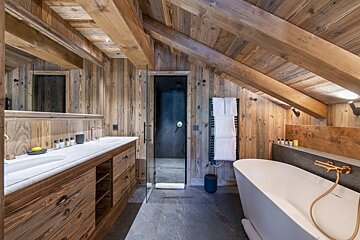 A bathroom with a bathtub and two sinks