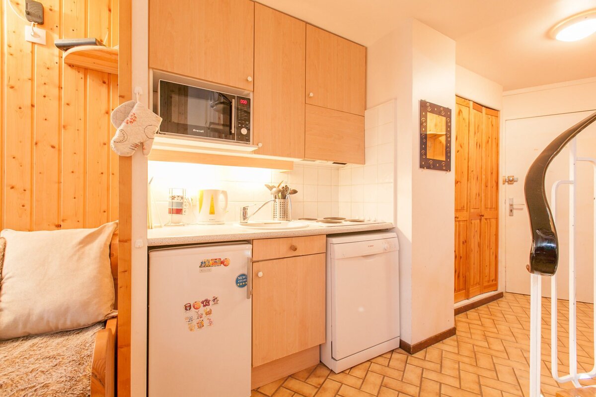 A small kitchen with a fridge that says ' disney ' on it