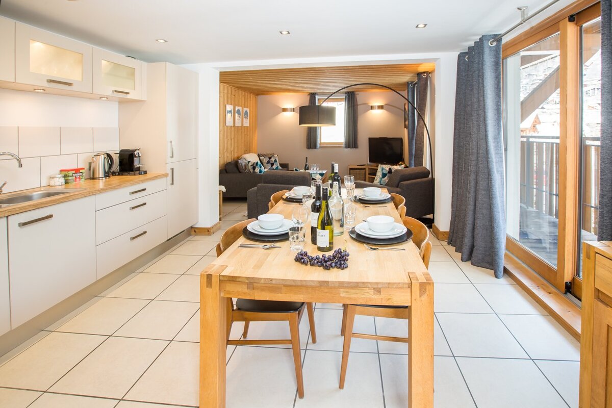 A dining table with a bottle of wine on it