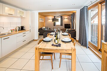 A dining table with a bottle of wine on it