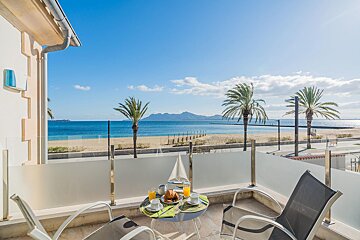 A balcony with a view of the ocean and palm trees