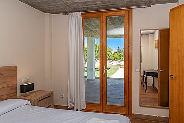 A bedroom with a bed a nightstand and a mirror