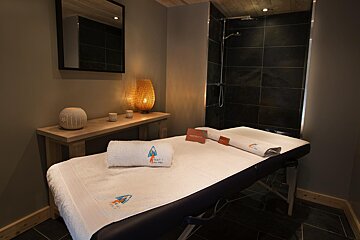 A massage table with a towel that says ' altitude ' on it