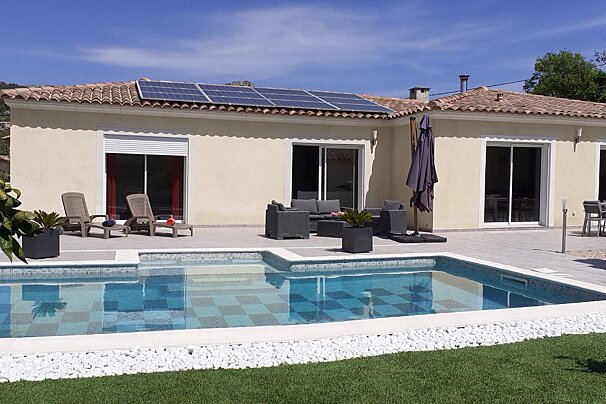 A house with a swimming pool and solar panels on the roof