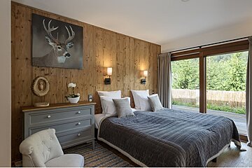 A bedroom with a deer painting on the wall above the bed