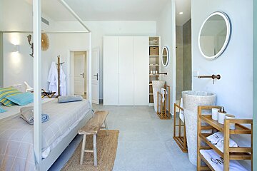 A bedroom with a canopy bed and two sinks