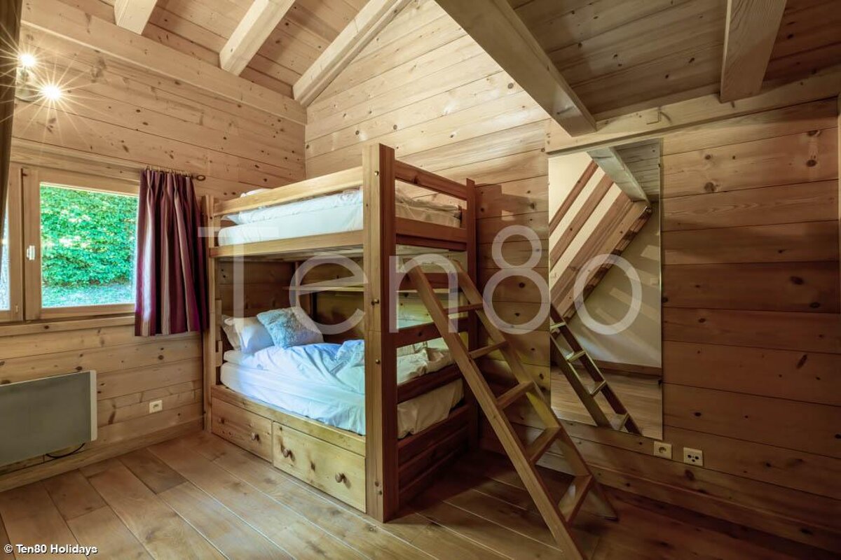 A bunk bed in a wooden cabin with the number ten80 on the bottom
