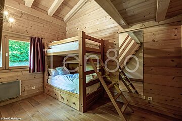 A bunk bed in a wooden cabin with the number ten80 on the bottom
