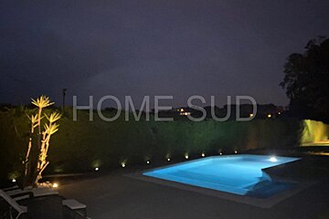 A swimming pool is lit up at night with the words home sud visible