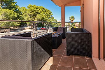 A balcony with two chairs and a table with cups on it
