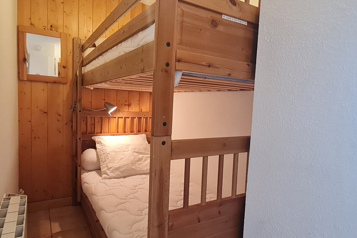 A wooden bunk bed with a label on it that says 