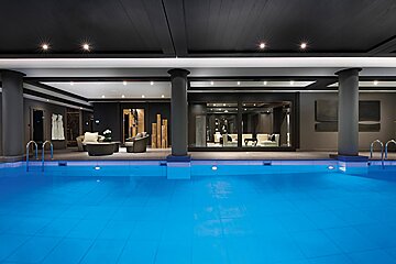 A large indoor swimming pool with a living room in the background