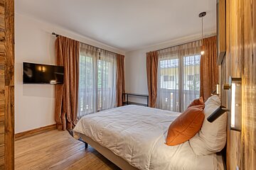 A bedroom with a large bed and a flat screen tv