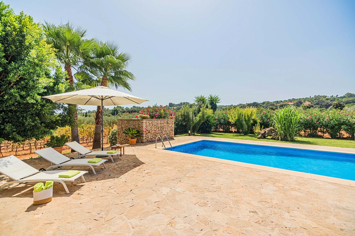 A swimming pool surrounded by lawn chairs and a white umbrella