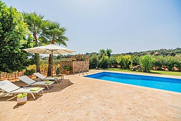 A swimming pool surrounded by lawn chairs and a white umbrella