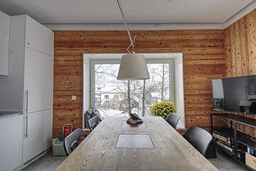 A kitchen with a table and chairs and a tv