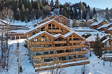 A large building with a lot of balconies is surrounded by snow