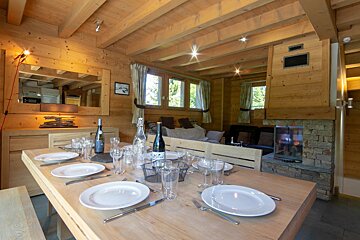 A bottle of wine sits on a wooden table