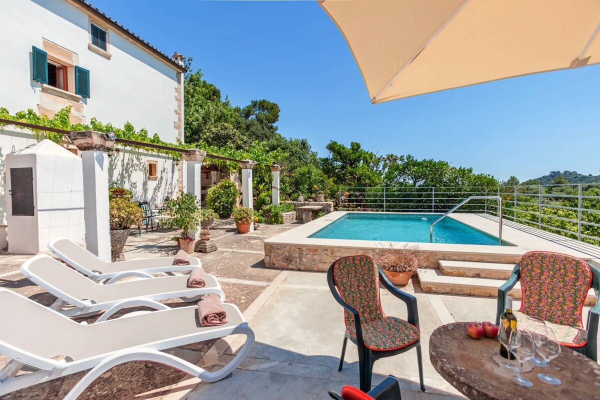 A swimming pool with a table and chairs in front of it