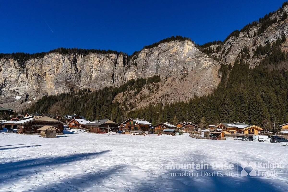A snowy landscape with a knight frank logo in the foreground