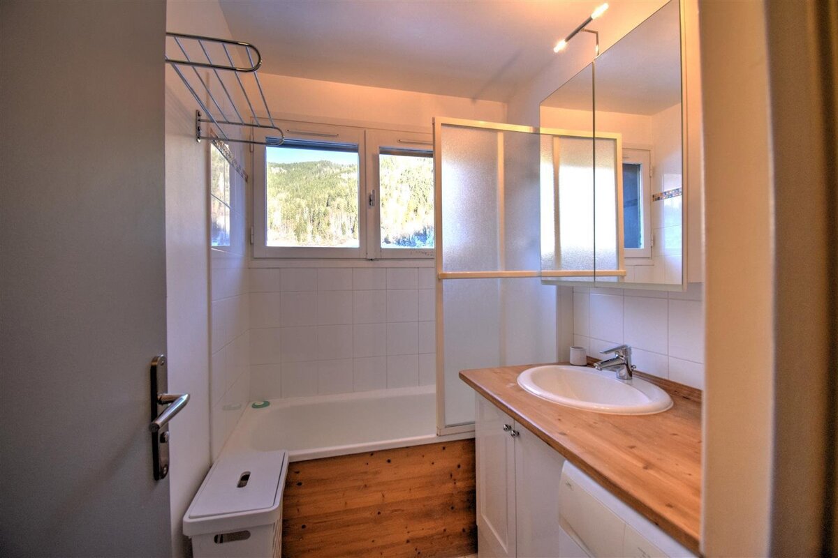 A bathroom with a sink a tub and a mirror