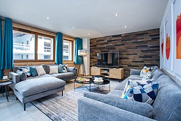 A living room with a sectional couch and a flat screen tv
