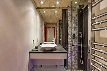 A bathroom with two sinks and a walk in shower