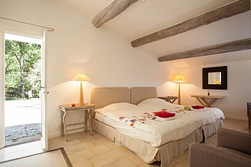 A bedroom with two beds and a mirror on the wall