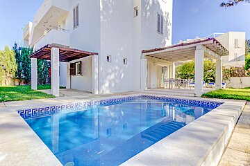 A white house with a swimming pool in front of it