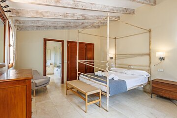 A bedroom with a canopy bed and a dresser