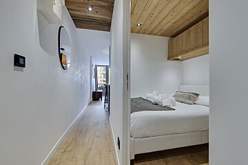 A bedroom with a bed and a mirror on the wall