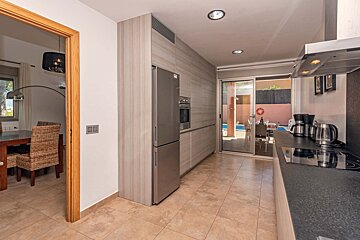 A kitchen with a sliding glass door that leads to a pool
