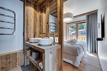 A bathroom with two sinks next to a bed