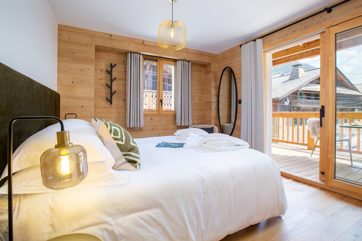 A bedroom with a large bed and a sliding glass door