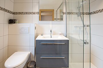 A bathroom with a toilet a sink and a shower