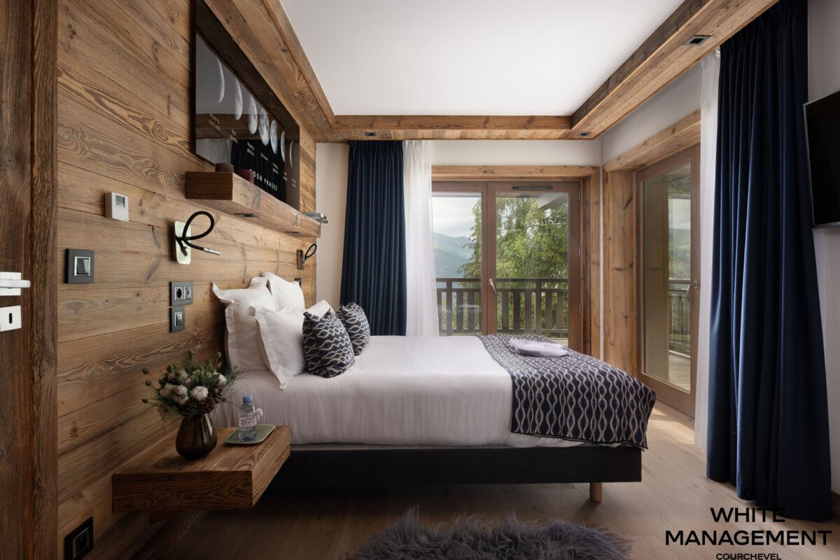 A bedroom with a rental designer logo on the corner