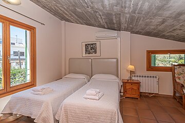 A bedroom with two beds and a picture on the wall